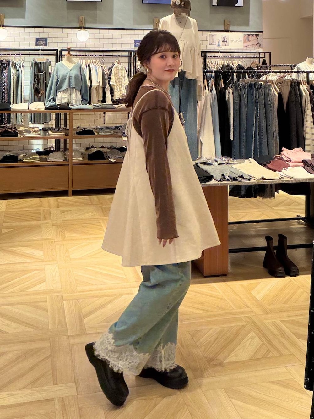 ホワイト系のスカート、ブラウン系のTシャツ/カットソー、ブルー系のデニムパンツを着用したレディースの秋コーディネートの2枚目の写真
