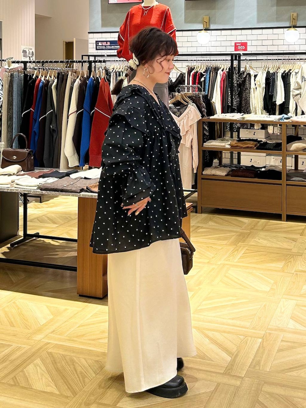 ホワイト系のスカート、ブラウン系のショルダーバッグ、ブラック系のサンダルを着用したレディースの秋コーディネートの6枚目の写真