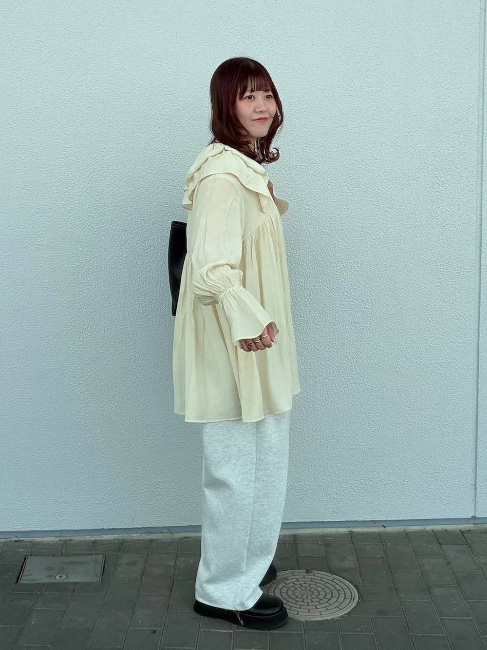 グレー系のスウェットパンツ、ブラック系のサンダル、ホワイト系のキャミソールを着用したレディースの春コーディネートの5枚目の写真