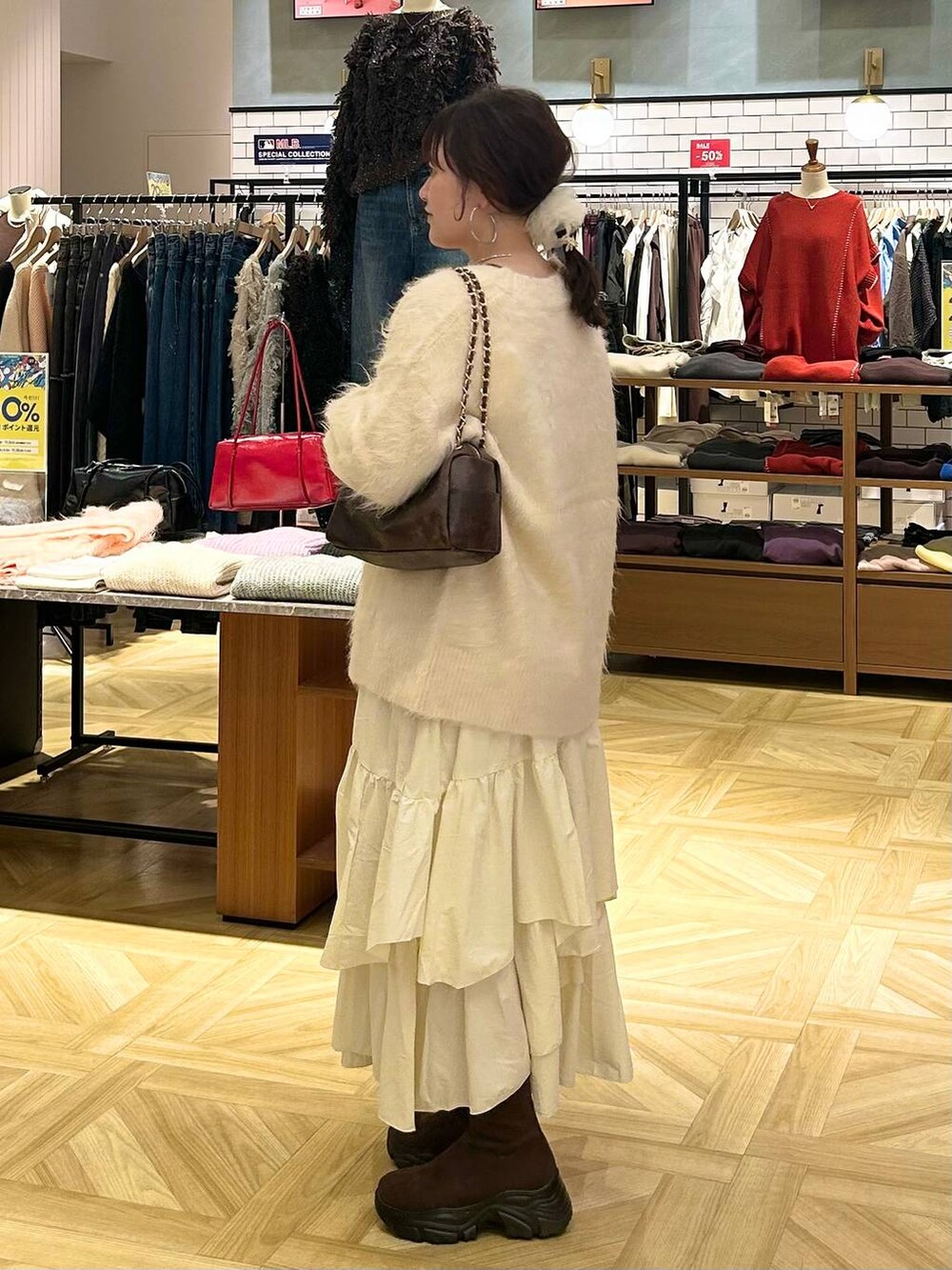 ホワイト系のスカート、ホワイト系のカーディガン/ボレロ、ブラウン系のショルダーバッグを着用したレディースの秋コーディネートの4枚目の写真