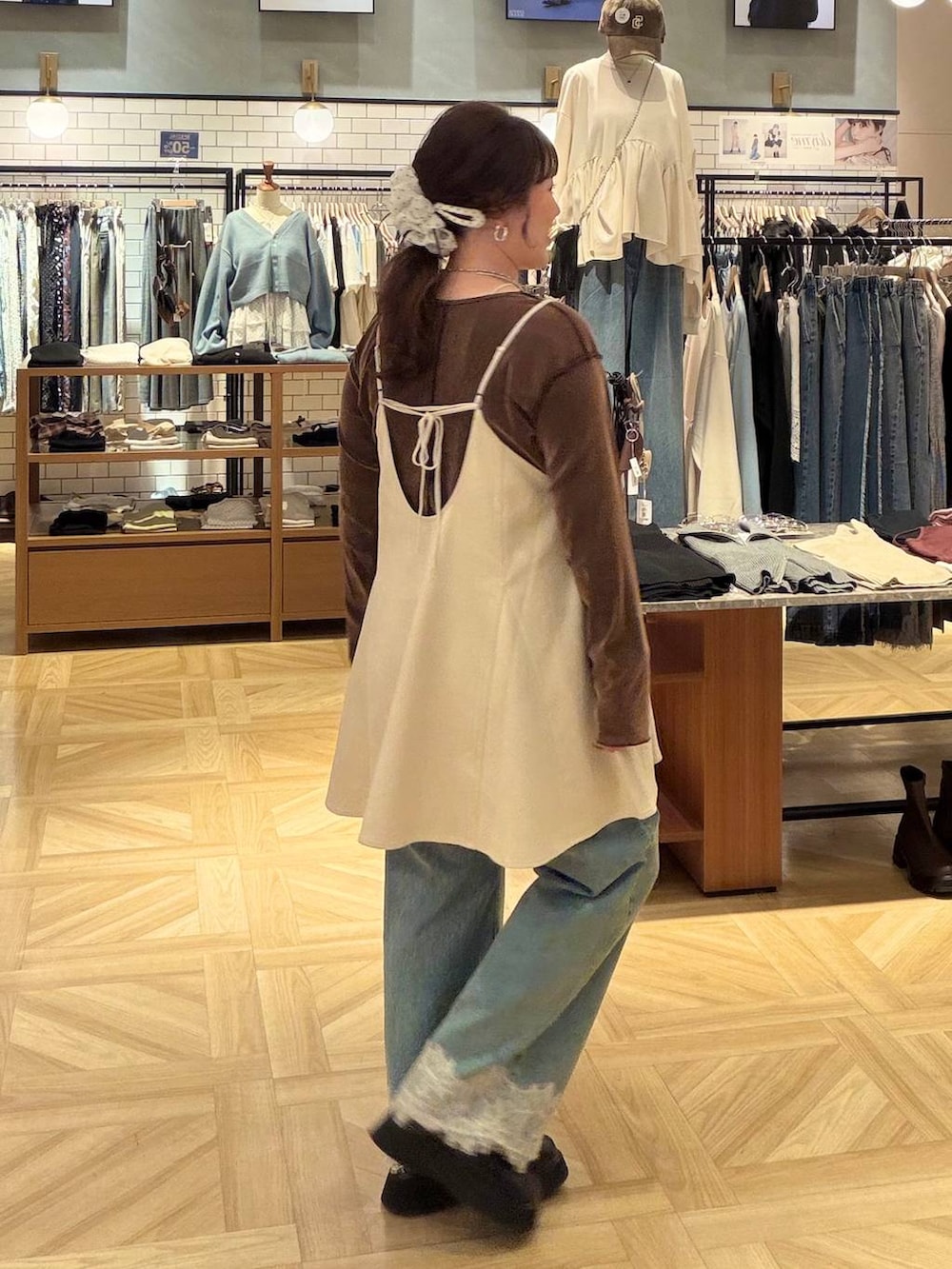 ホワイト系のスカート、ブラウン系のTシャツ/カットソー、ブルー系のデニムパンツを着用したレディースの秋コーディネートの3枚目の写真
