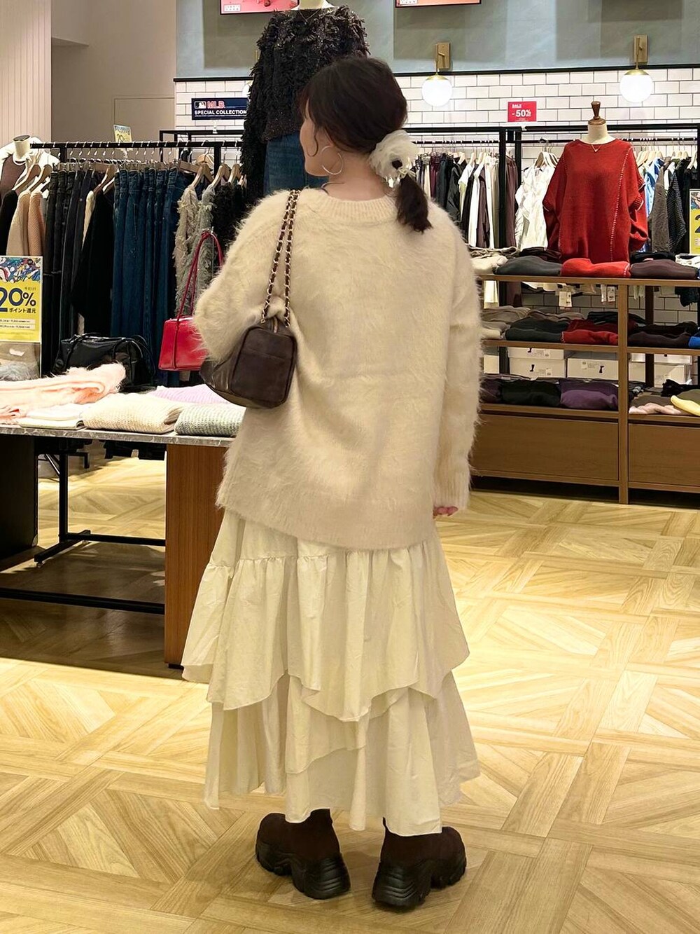 ホワイト系のスカート、ホワイト系のカーディガン/ボレロ、ブラウン系のショルダーバッグを着用したレディースの秋コーディネートの5枚目の写真