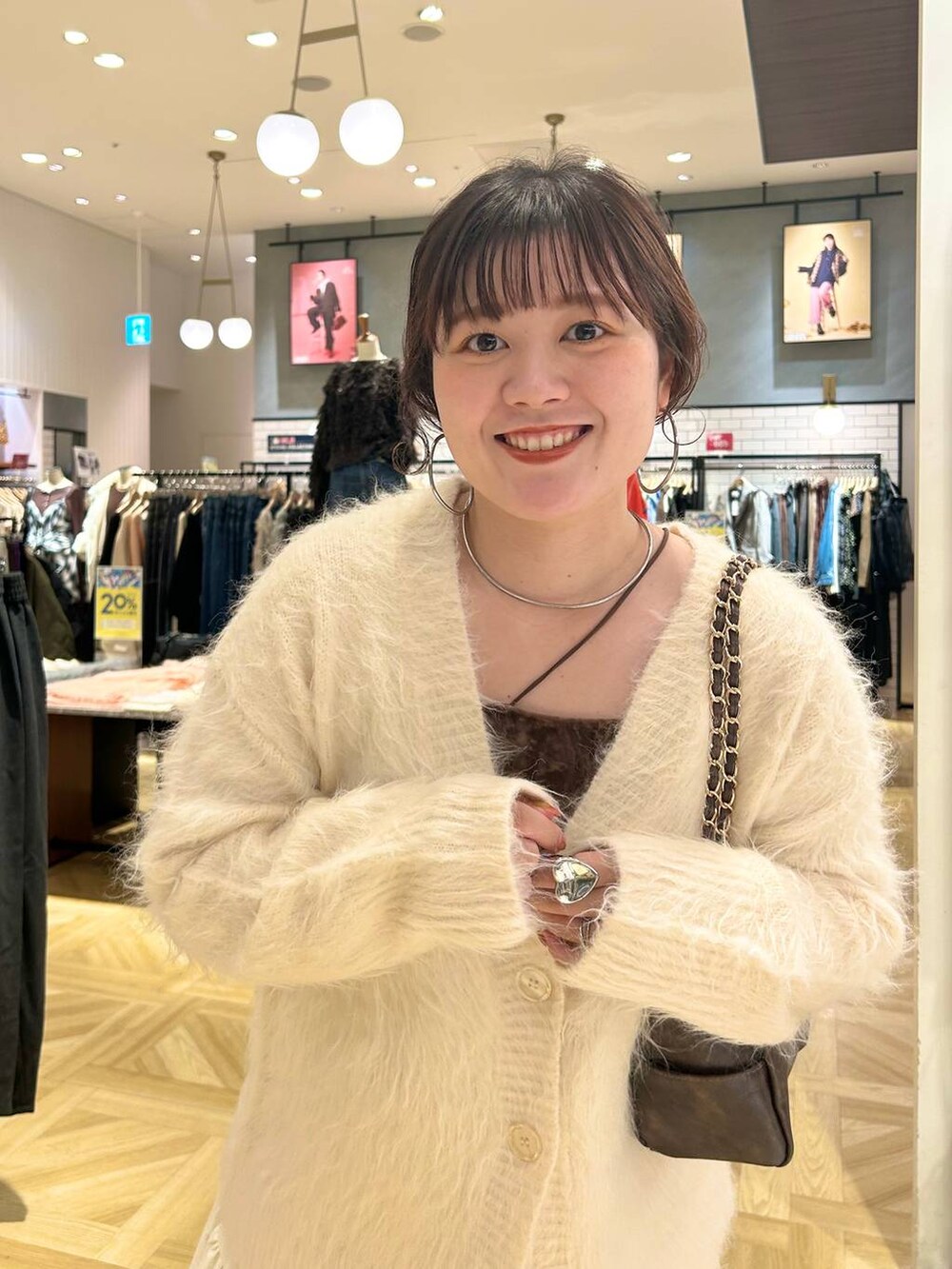 ホワイト系のスカート、ホワイト系のカーディガン/ボレロ、ブラウン系のショルダーバッグを着用したレディースの秋コーディネートの3枚目の写真