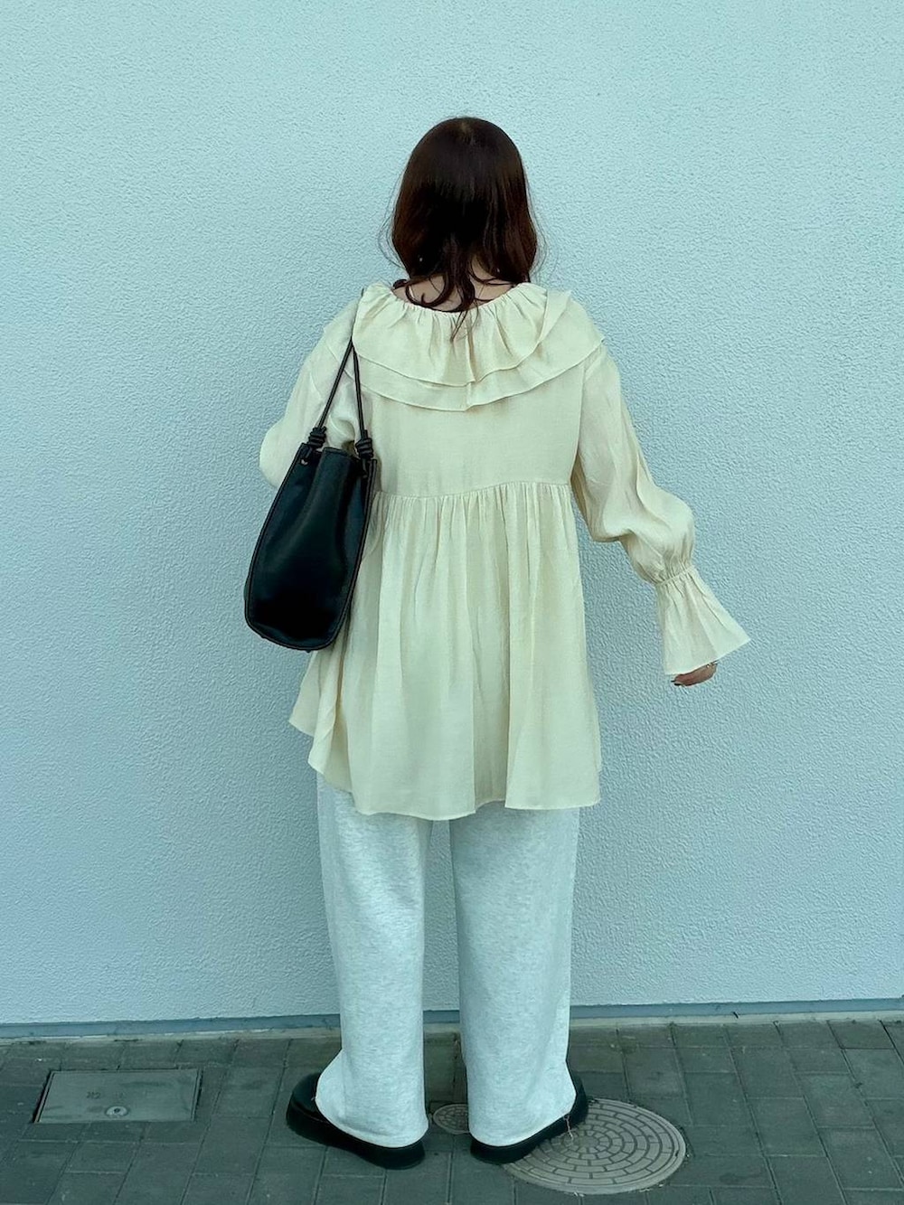 グレー系のスウェットパンツ、ブラック系のサンダル、ホワイト系のキャミソールを着用したレディースの春コーディネートの4枚目の写真