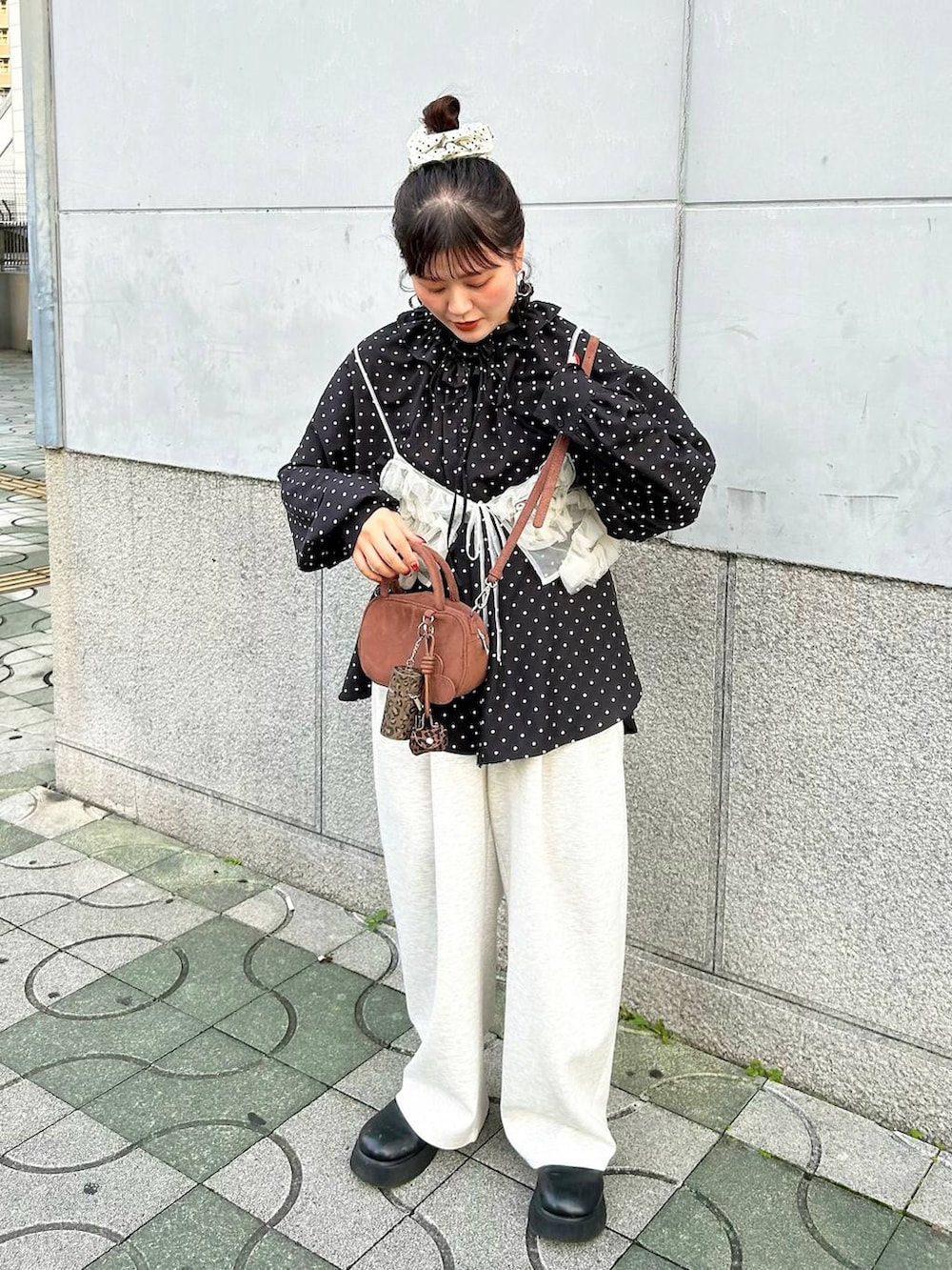 グレー系のスウェットパンツ、ブラック系のサンダル、ブラウン系のボストンバッグを着用したレディースの秋コーディネートの2枚目の写真