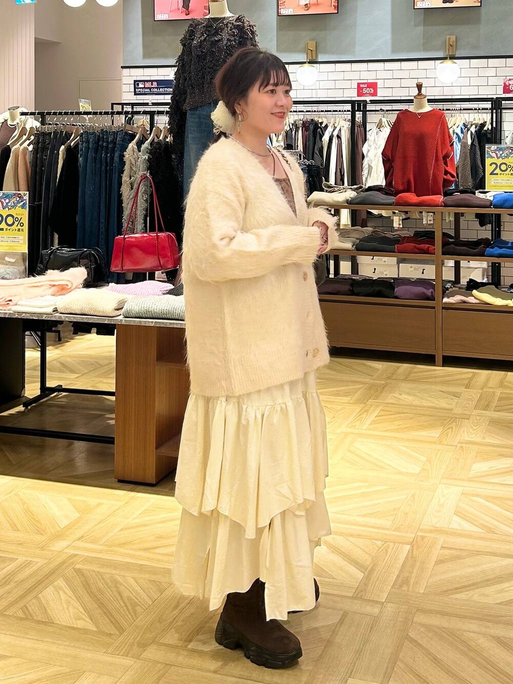 ホワイト系のスカート、ホワイト系のカーディガン/ボレロ、ブラウン系のショルダーバッグを着用したレディースの秋コーディネートの6枚目の写真