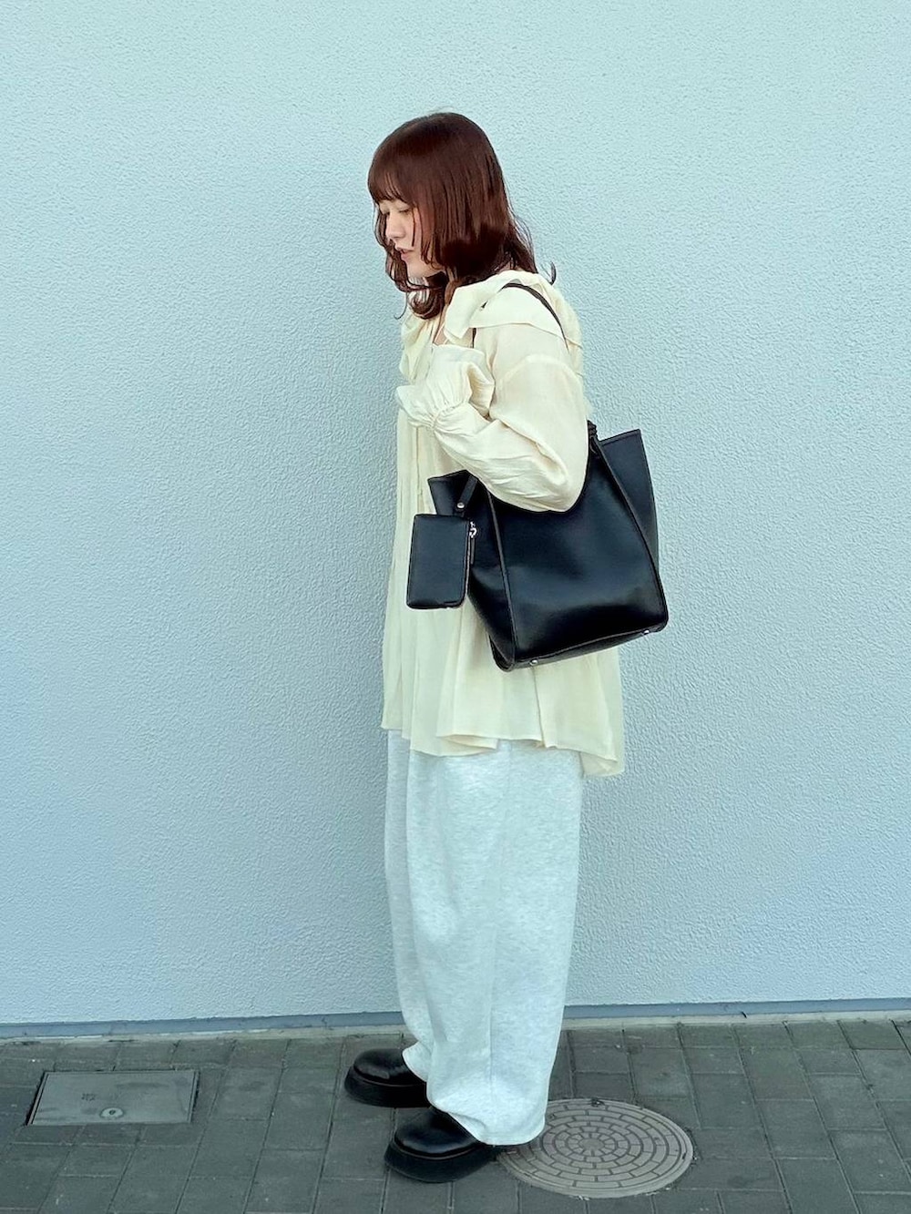 グレー系のスウェットパンツ、ブラック系のサンダル、ホワイト系のキャミソールを着用したレディースの春コーディネートの3枚目の写真