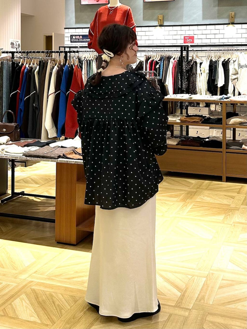 ホワイト系のスカート、ブラウン系のショルダーバッグ、ブラック系のサンダルを着用したレディースの秋コーディネートの5枚目の写真