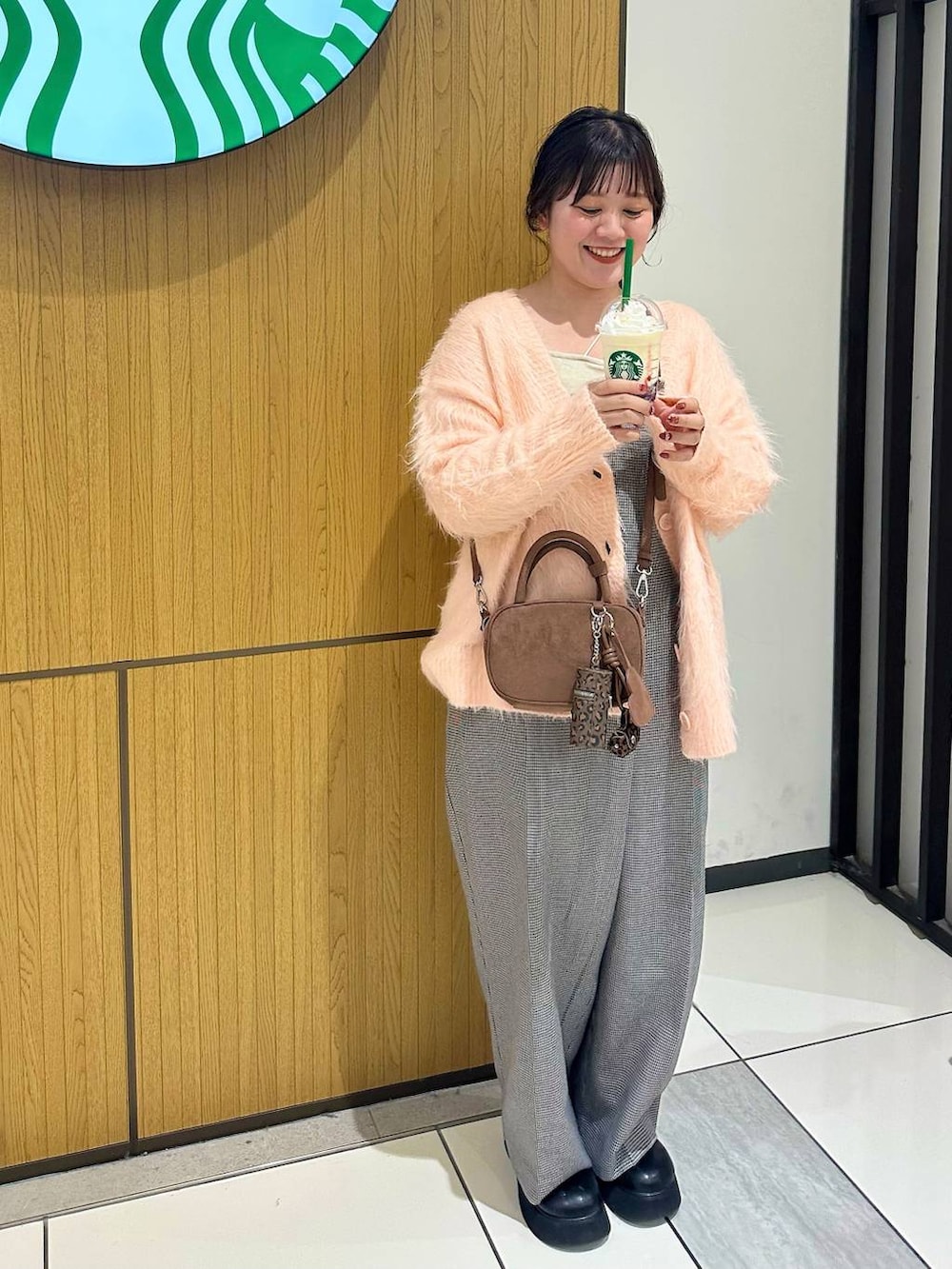 ブラック系のサンダル、ブラウン系のボストンバッグ、ピンク系のカーディガン/ボレロを着用したレディースの秋コーディネートの2枚目の写真