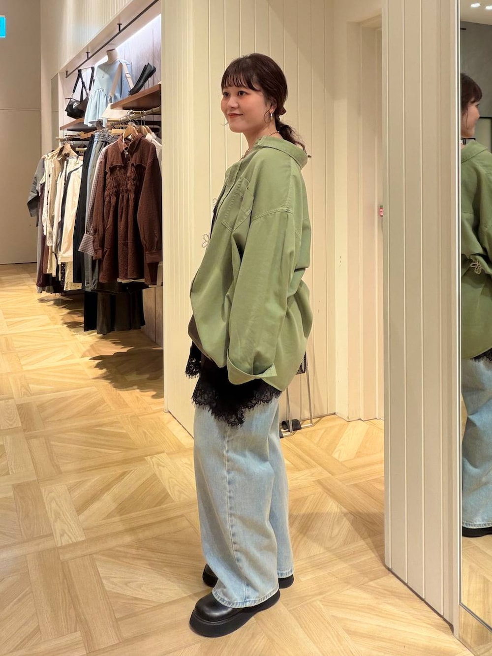 ブラック系のキャミソール、ブルー系のデニムパンツ、グリーン系のシャツ/ブラウスを着用したレディースの秋コーディネートの3枚目の写真