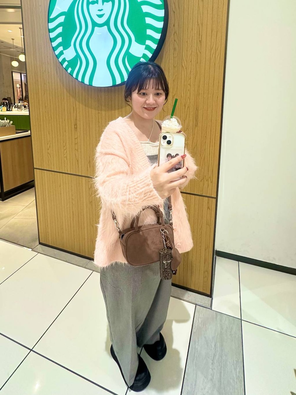 ブラック系のサンダル、ブラウン系のボストンバッグ、ピンク系のカーディガン/ボレロを着用したレディースの秋コーディネートの4枚目の写真