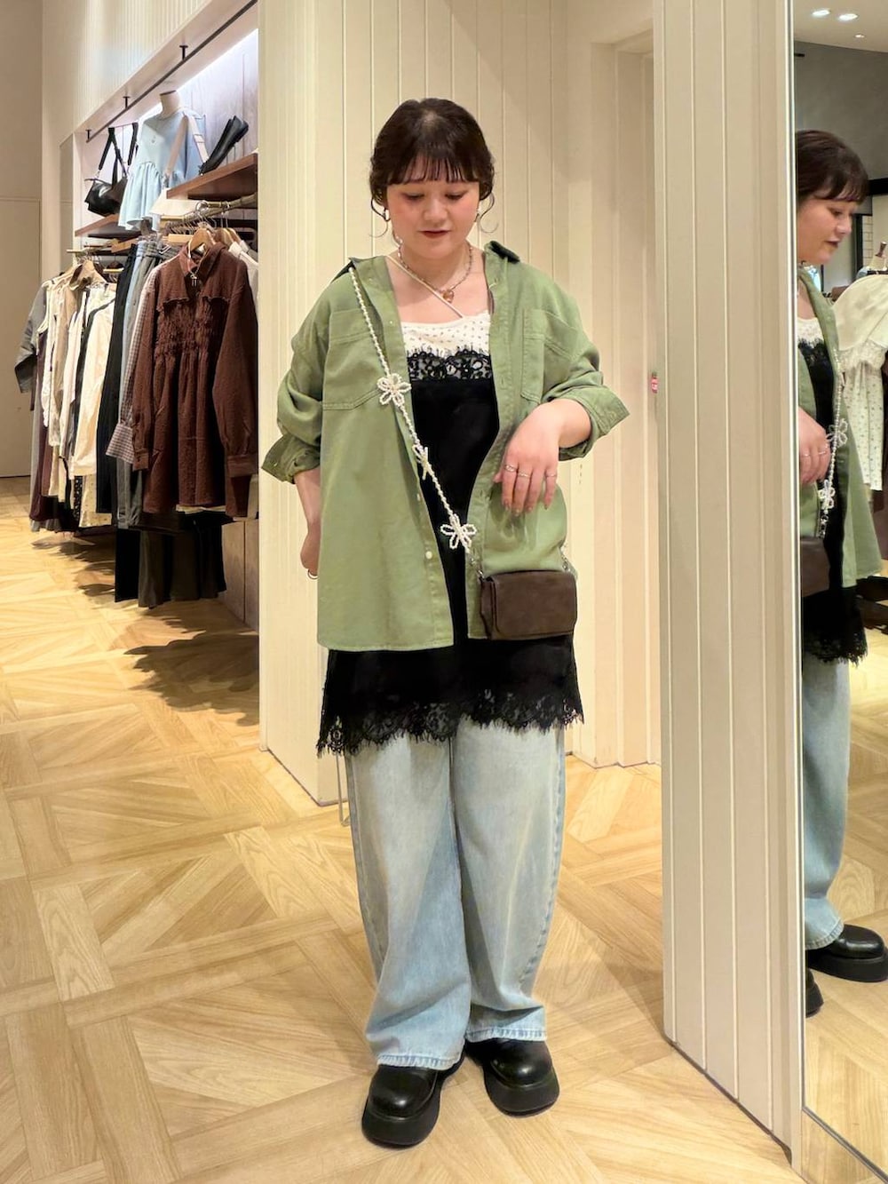 ブラック系のキャミソール、ブルー系のデニムパンツ、グリーン系のシャツ/ブラウスを着用したレディースの秋コーディネートの4枚目の写真