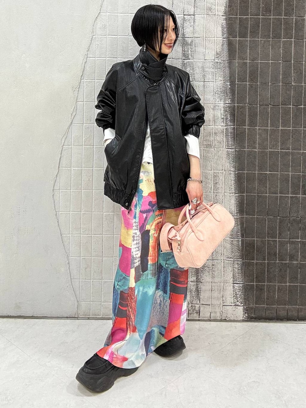 ブラック系のローファー、ピンク系のボストンバッグ、ブラック系のブルゾンを着用したレディースの春コーディネートの2枚目の写真