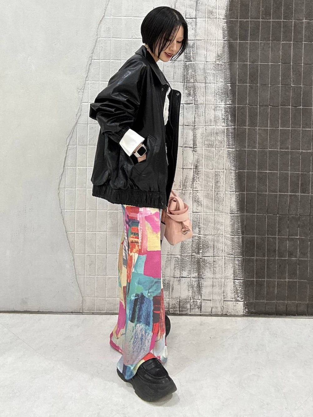 ブラック系のローファー、ピンク系のボストンバッグ、ブラック系のブルゾンを着用したレディースの春コーディネートの5枚目の写真