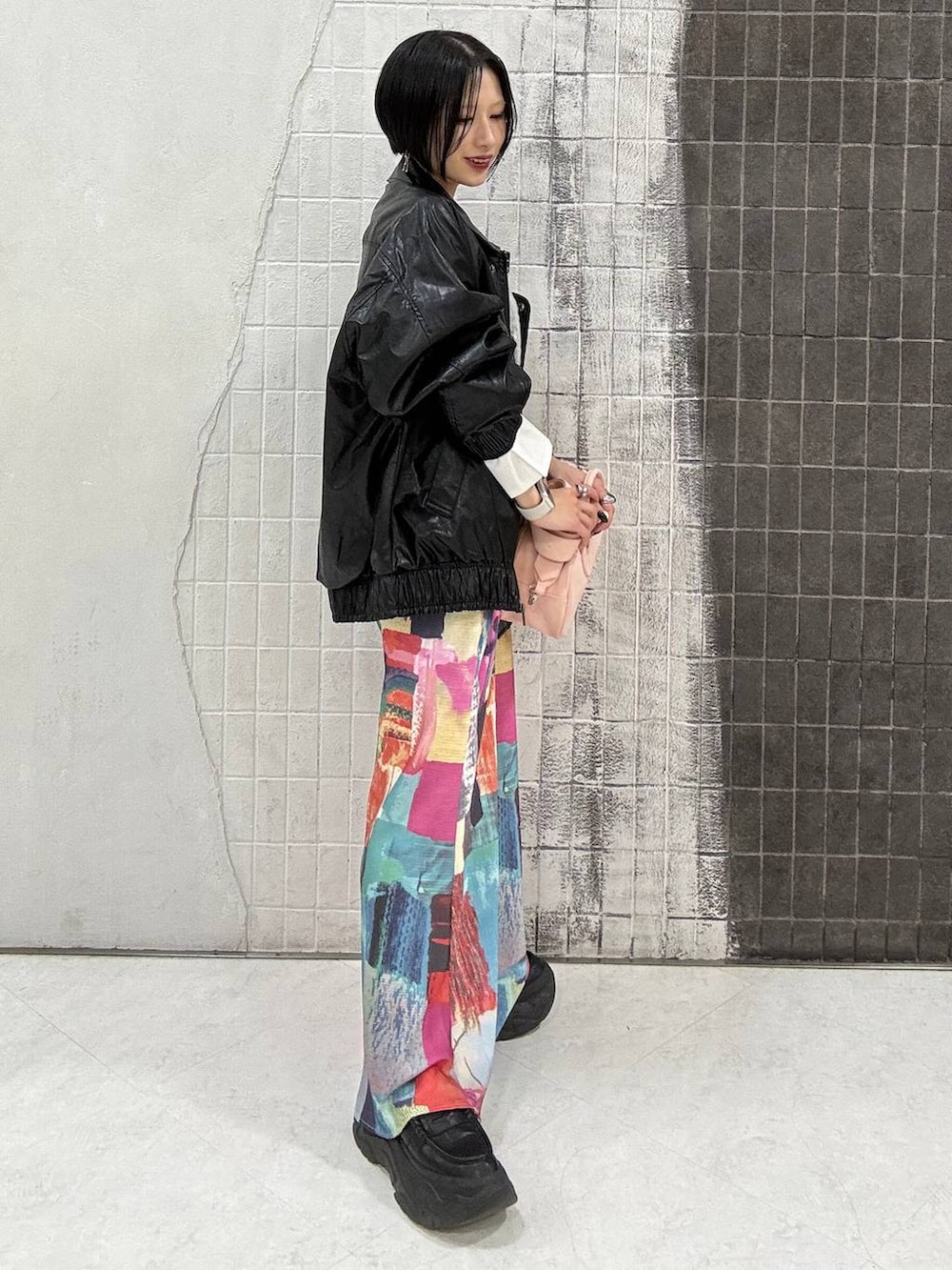 ブラック系のローファー、ピンク系のボストンバッグ、ブラック系のブルゾンを着用したレディースの春コーディネートの4枚目の写真