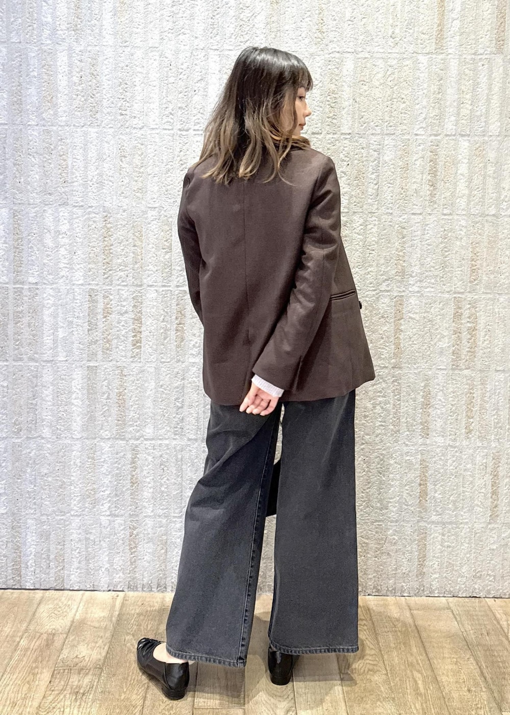 ブラック系のハンドバッグ、ホワイト系のキャミソール、ブラック系のパンプスを着用したレディースの秋コーディネートの4枚目の写真