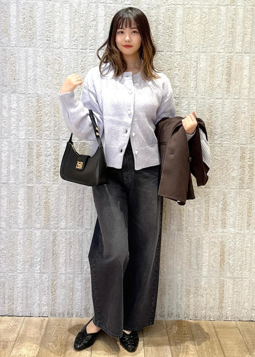 ブラック系のハンドバッグ、ホワイト系のキャミソール、ブラック系のパンプスを着用したレディースの秋コーディネートの2枚目の写真