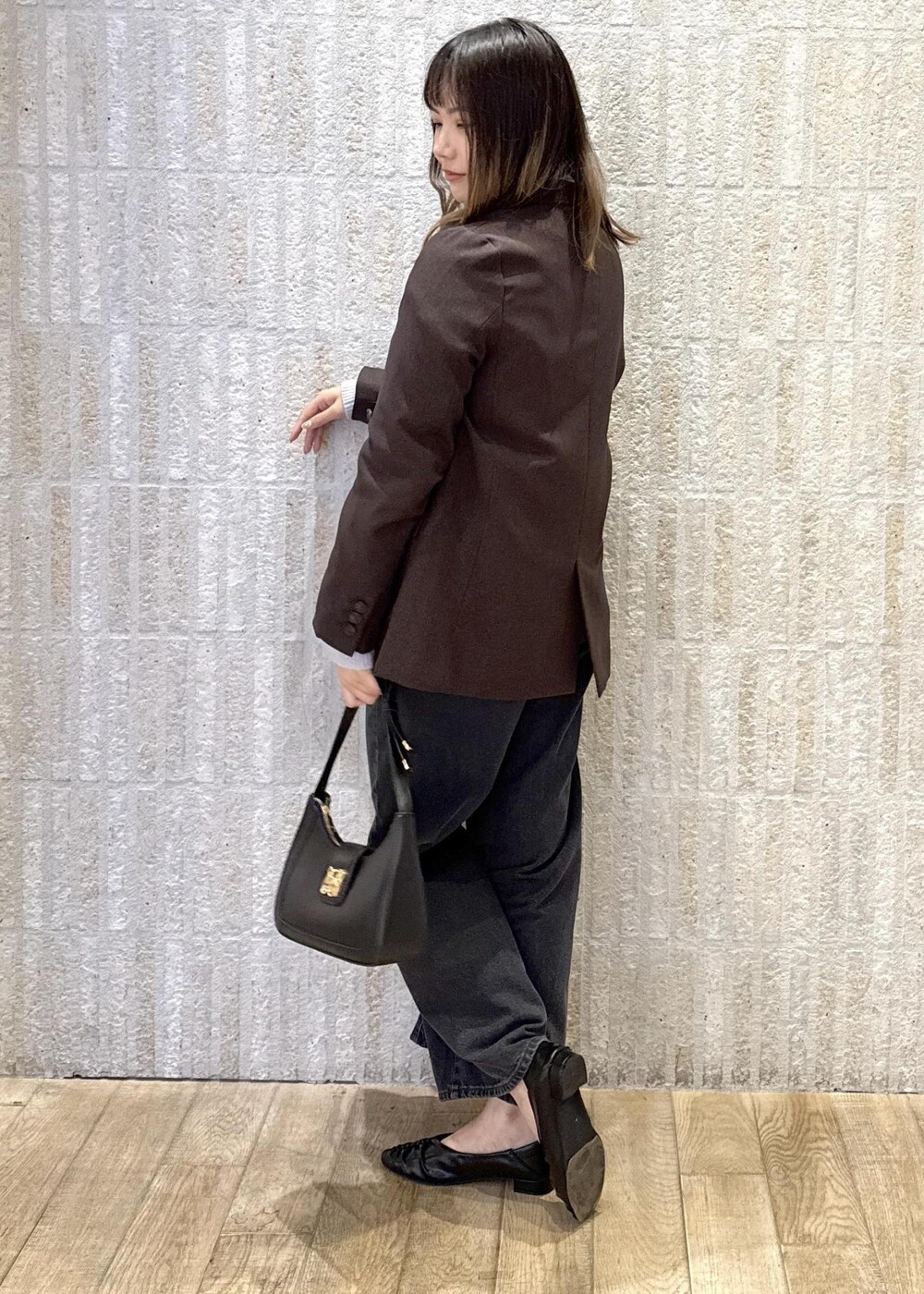 ブラック系のハンドバッグ、ホワイト系のキャミソール、ブラック系のパンプスを着用したレディースの秋コーディネートの3枚目の写真