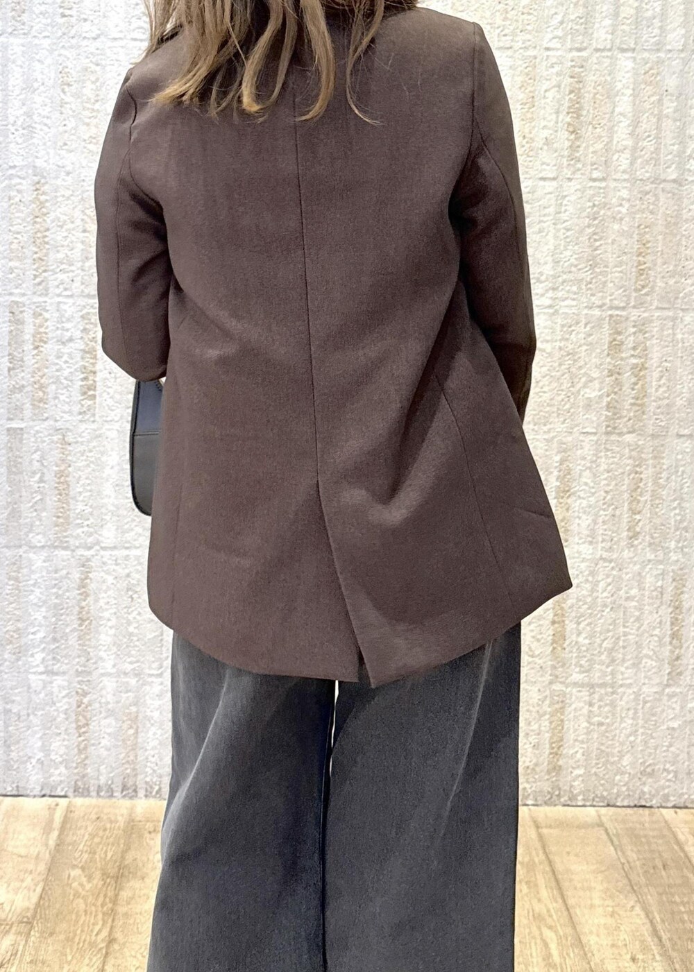 ブラック系のハンドバッグ、ホワイト系のキャミソール、ブラック系のパンプスを着用したレディースの秋コーディネートの7枚目の写真