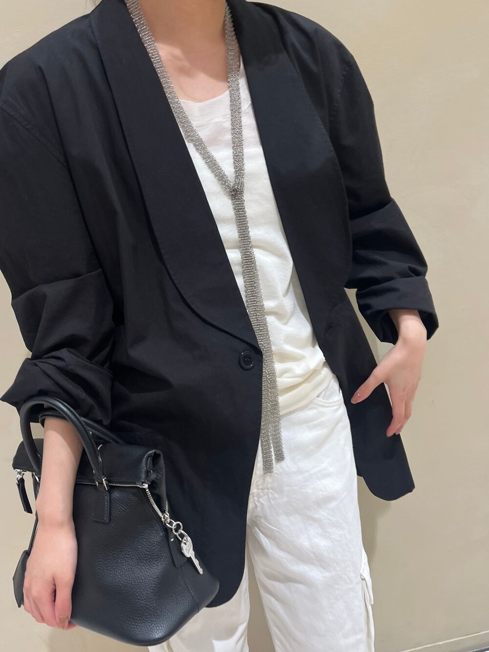 ホワイト系のデニムパンツ、ホワイト系のニット/セーターを着用したレディースの春コーディネートの4枚目の写真