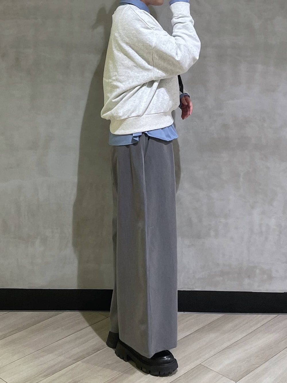 ブラック系のローファー、グレー系のスウェット、グレー系のスラックスを着用したレディースの冬コーディネートの4枚目の写真