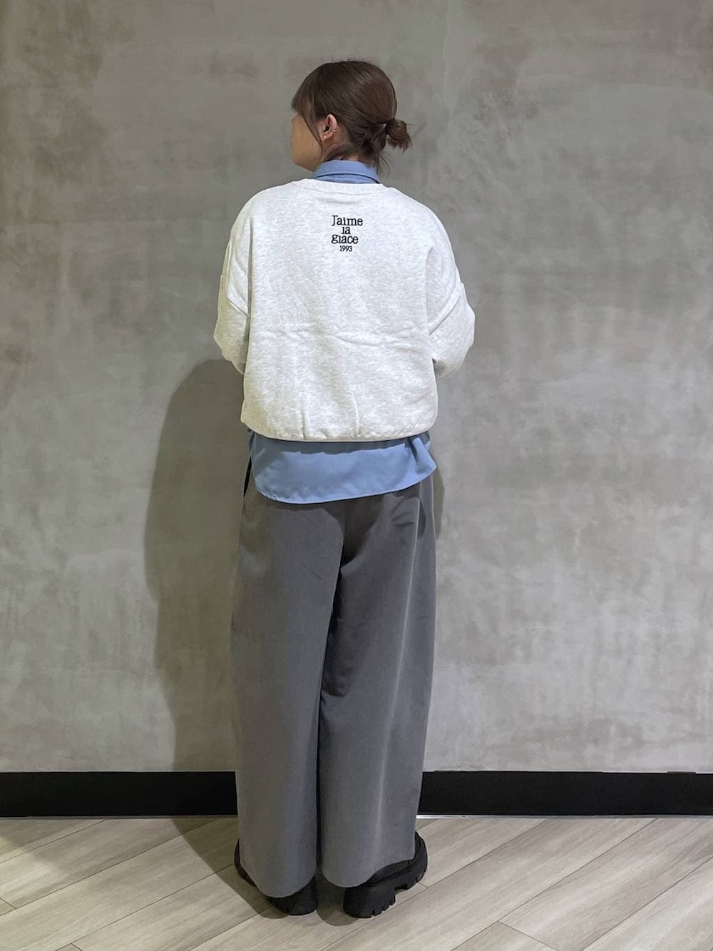 ブラック系のローファー、グレー系のスウェット、グレー系のスラックスを着用したレディースの冬コーディネートの3枚目の写真