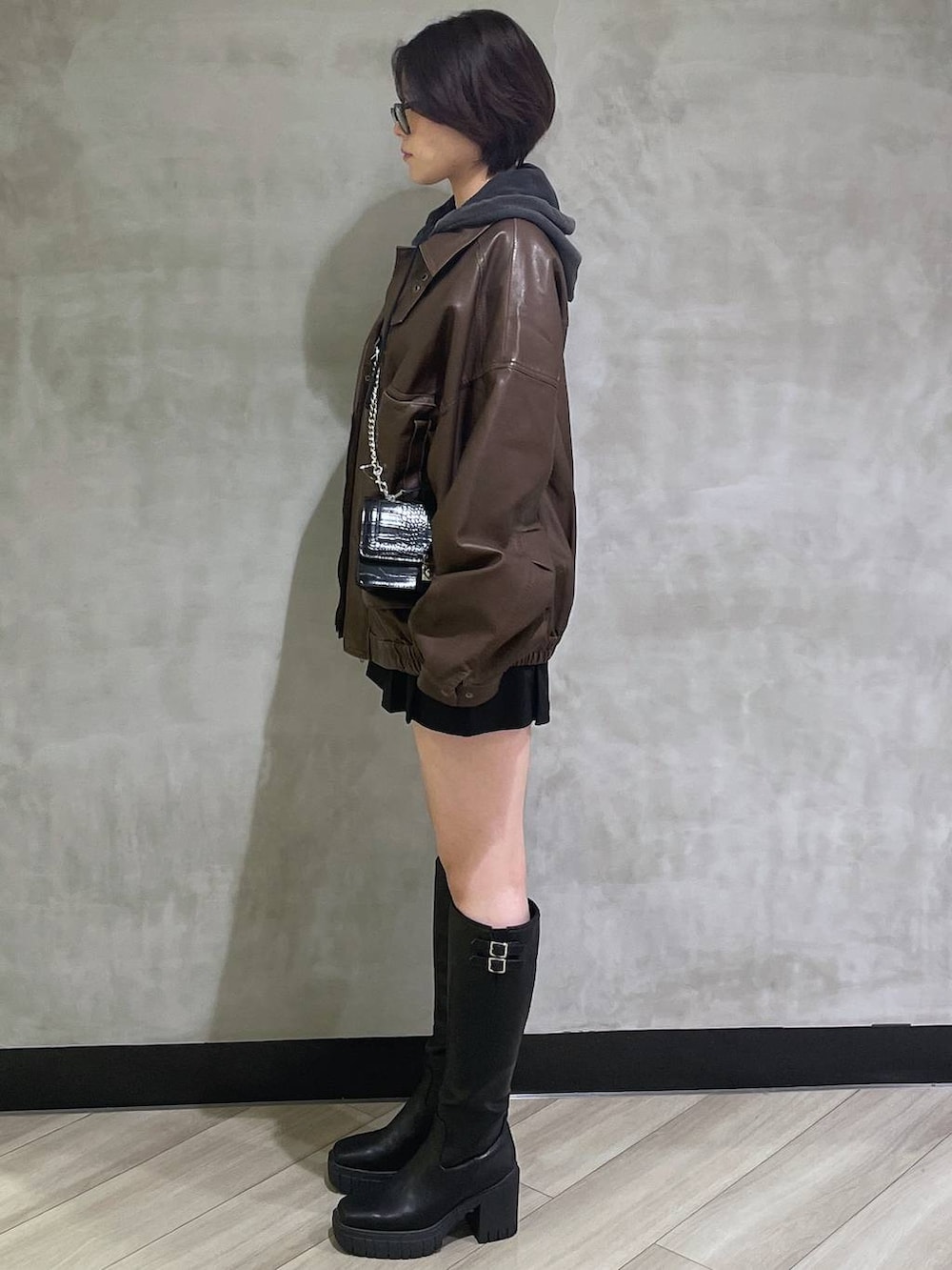 ブラック系のその他パンツ、ブラック系のブーツ、ブラック系のハンドバッグを着用したレディースの秋コーディネートの2枚目の写真