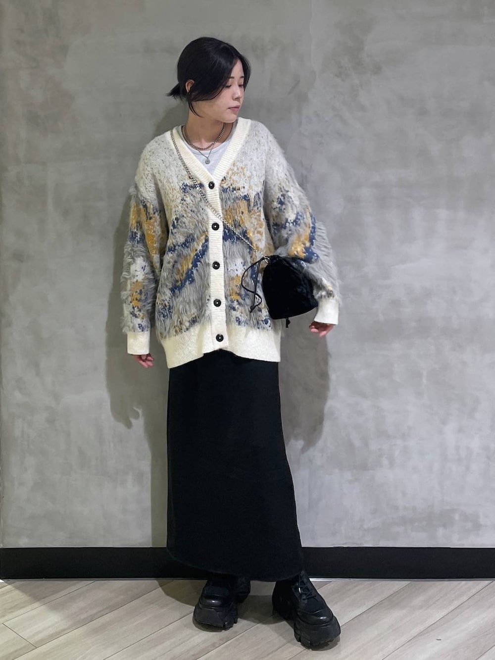 ブラック系のブーツ、ホワイト系のTシャツ/カットソー、ホワイト系のカーディガン/ボレロを着用したレディースの冬コーディネートの5枚目の写真