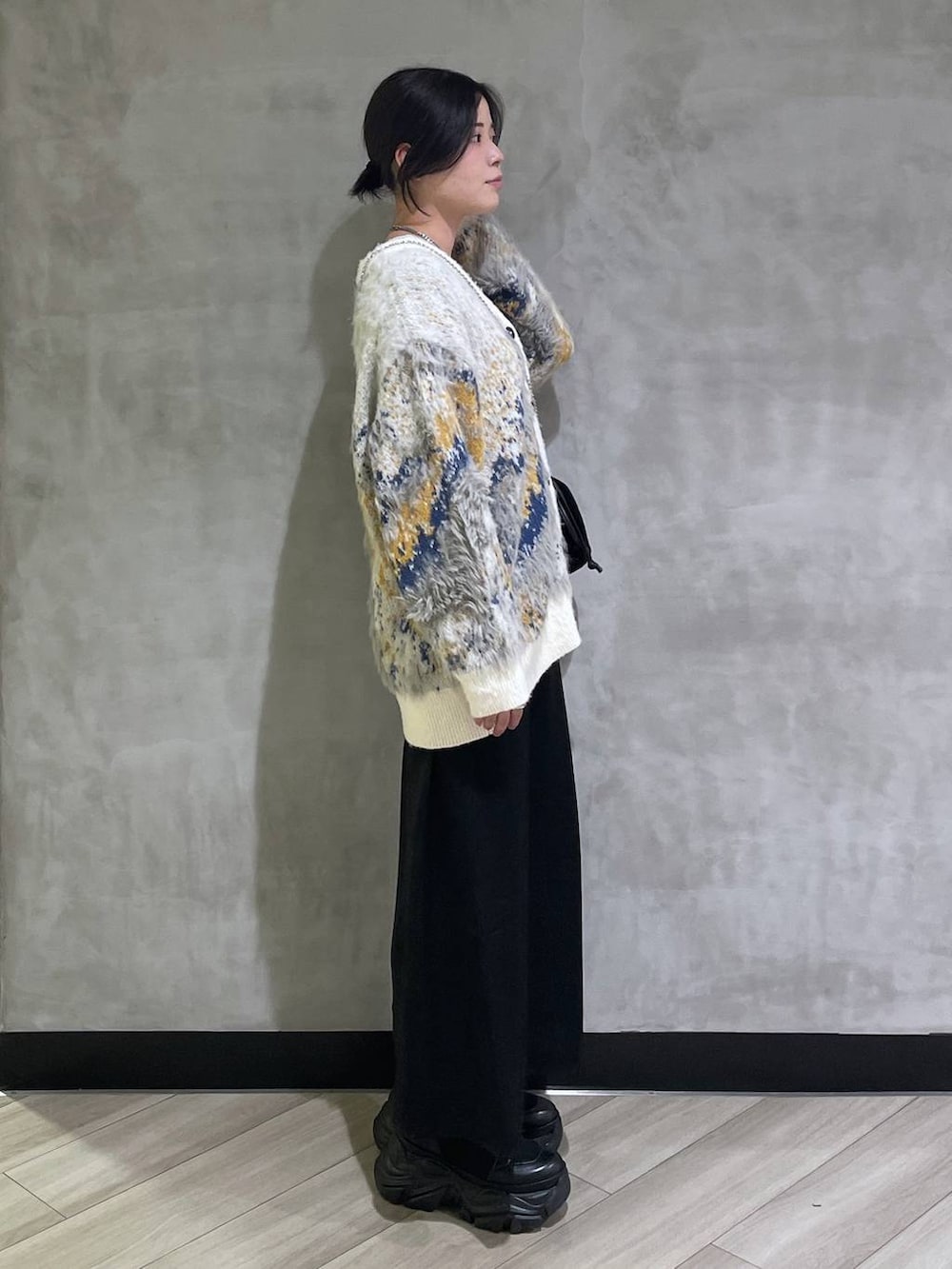 ブラック系のブーツ、ホワイト系のTシャツ/カットソー、ホワイト系のカーディガン/ボレロを着用したレディースの冬コーディネートの4枚目の写真