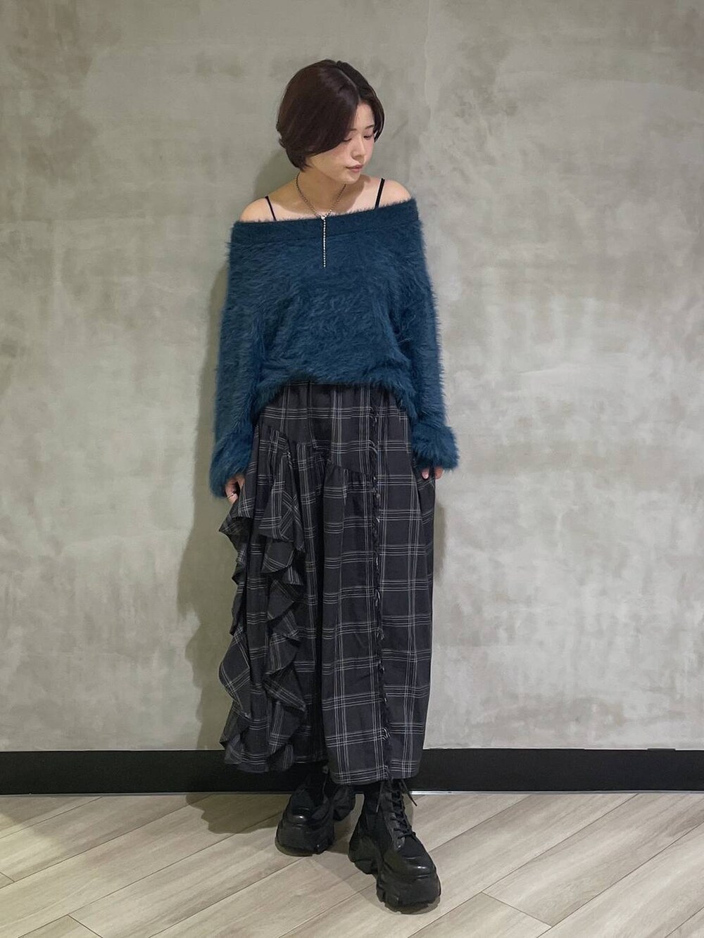 ホワイト系のブーツ、ブルー系のニット/セーター、ブラック系のスカートを着用したレディースの秋コーディネートの6枚目の写真