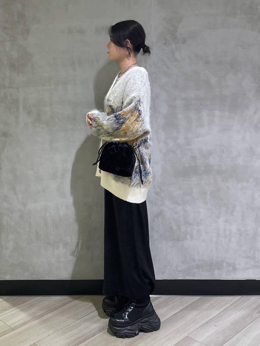 ブラック系のブーツ、ホワイト系のTシャツ/カットソー、ホワイト系のカーディガン/ボレロを着用したレディースの冬コーディネートの2枚目の写真