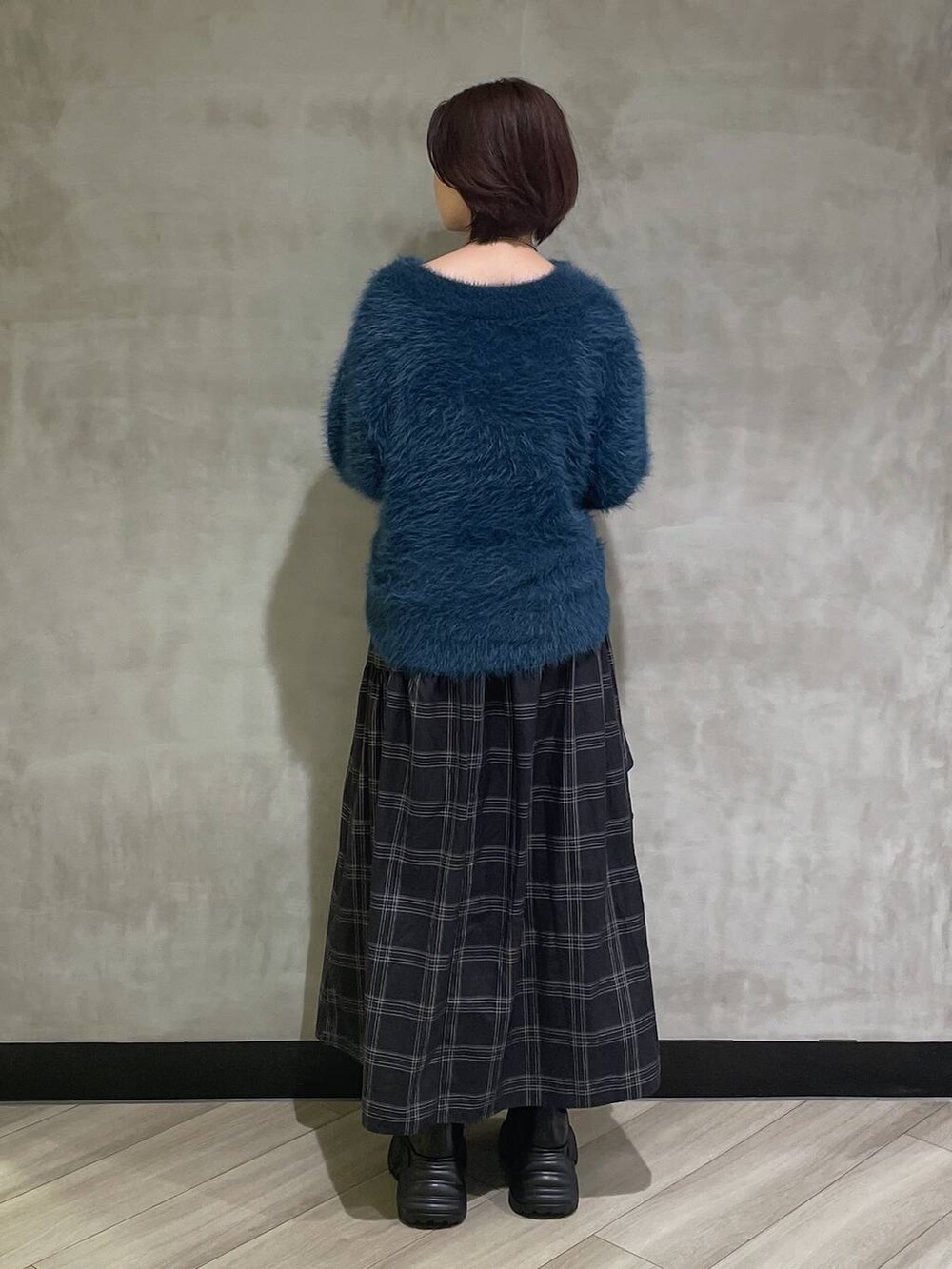 ホワイト系のブーツ、ブルー系のニット/セーター、ブラック系のスカートを着用したレディースの秋コーディネートの3枚目の写真