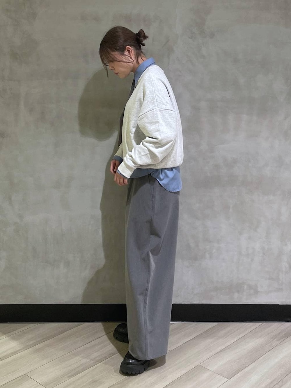 ブラック系のローファー、グレー系のスウェット、グレー系のスラックスを着用したレディースの冬コーディネートの2枚目の写真