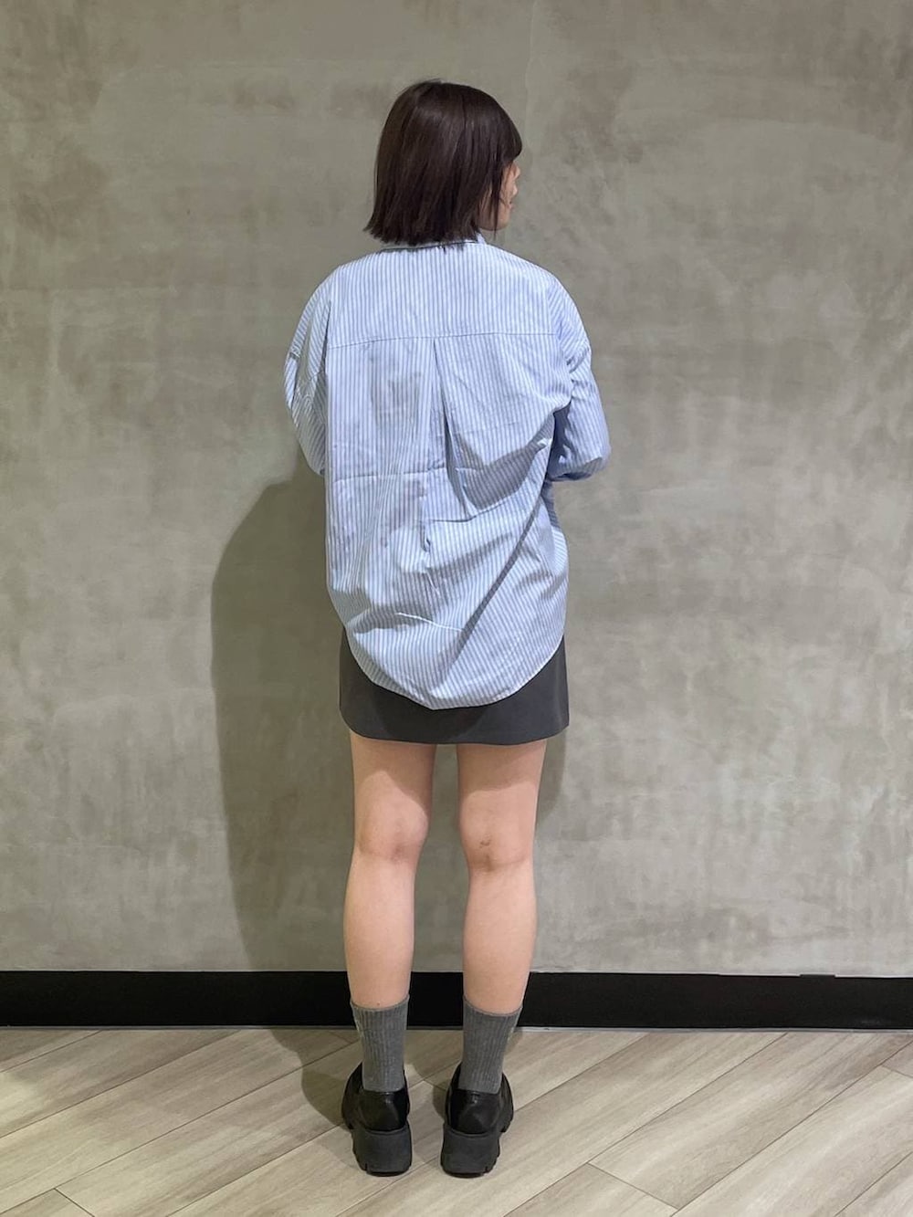 ベージュ系のボストンバッグ、ブラック系のローファー、グレー系のスカートを着用したレディースの冬コーディネートの3枚目の写真