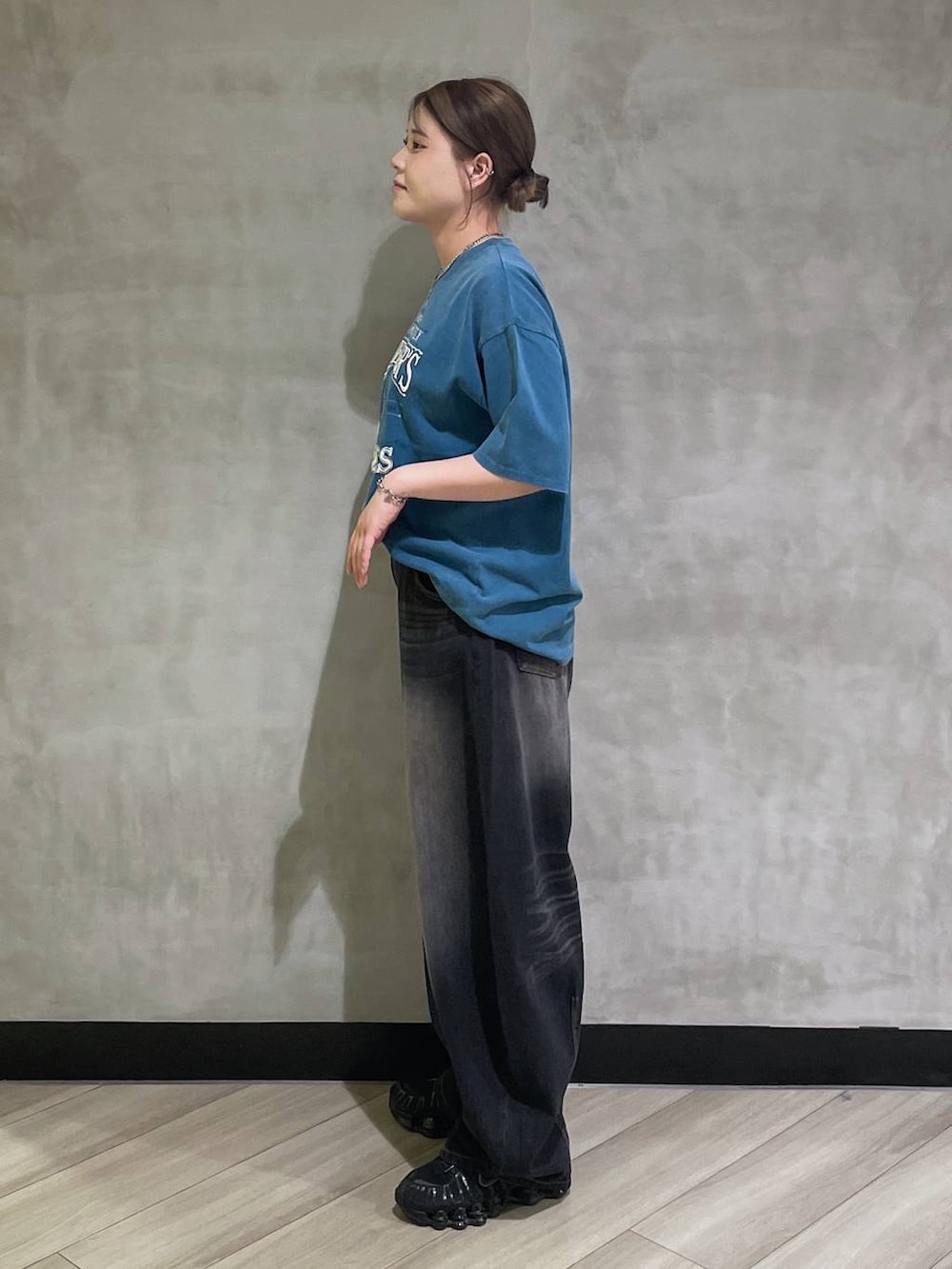 ブルー系のTシャツ/カットソー、ブラック系のデニムパンツを着用したレディースの春コーディネートの2枚目の写真