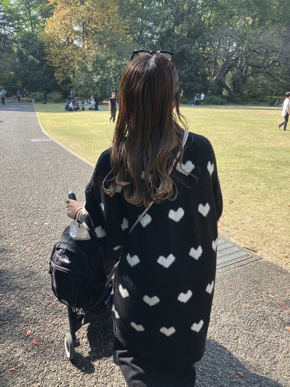 ブラック系のニット/セーター、ホワイト系のスニーカー、ブラック系のスカートを着用したレディースの秋コーディネートの3枚目の写真