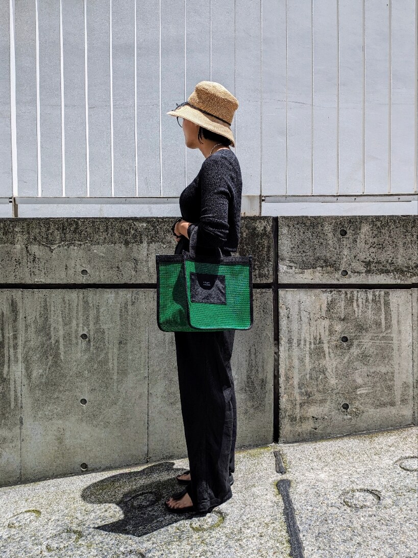 グリーン系のハンドバッグを着用したレディースの夏コーディネートの2枚目の写真