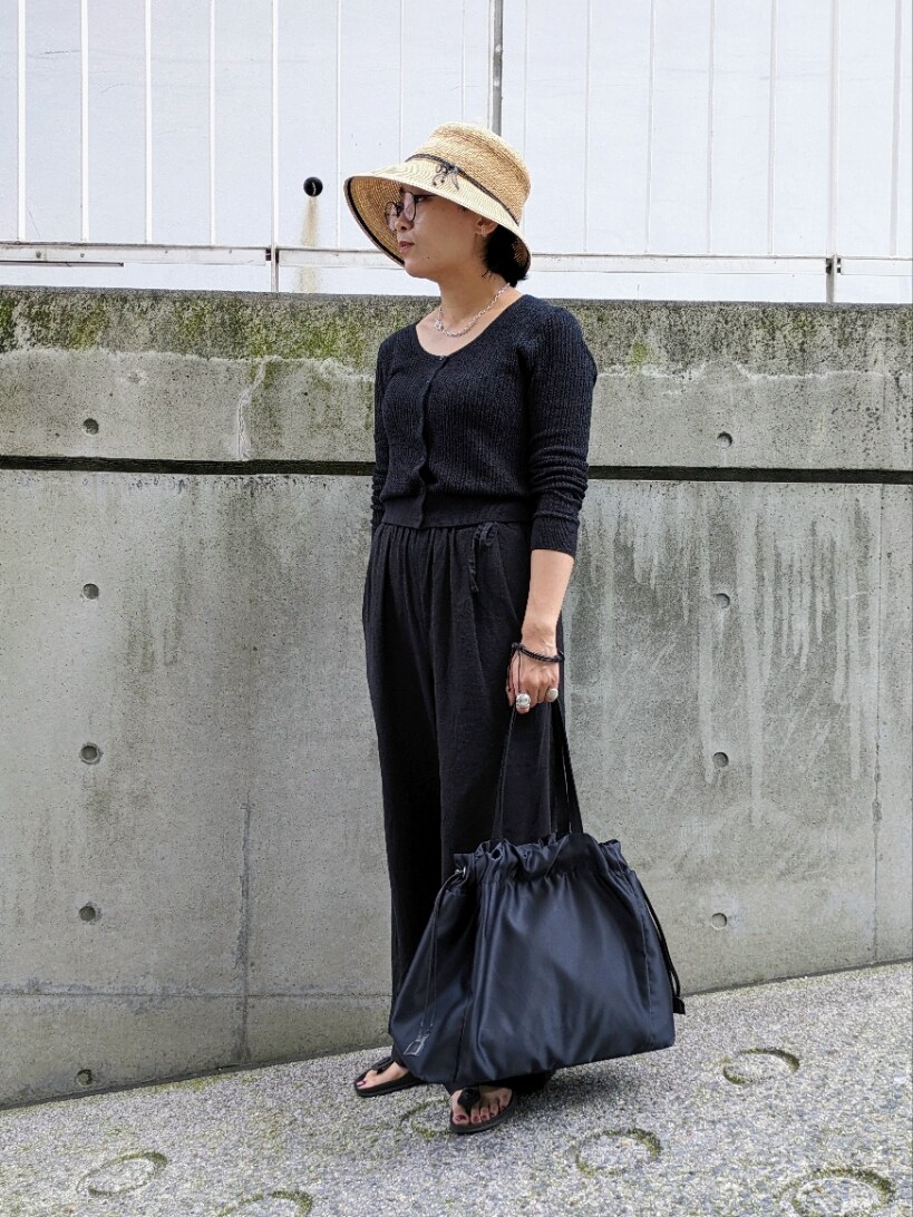 ブラック系のトートバッグを着用したレディースの夏コーディネートの2枚目の写真