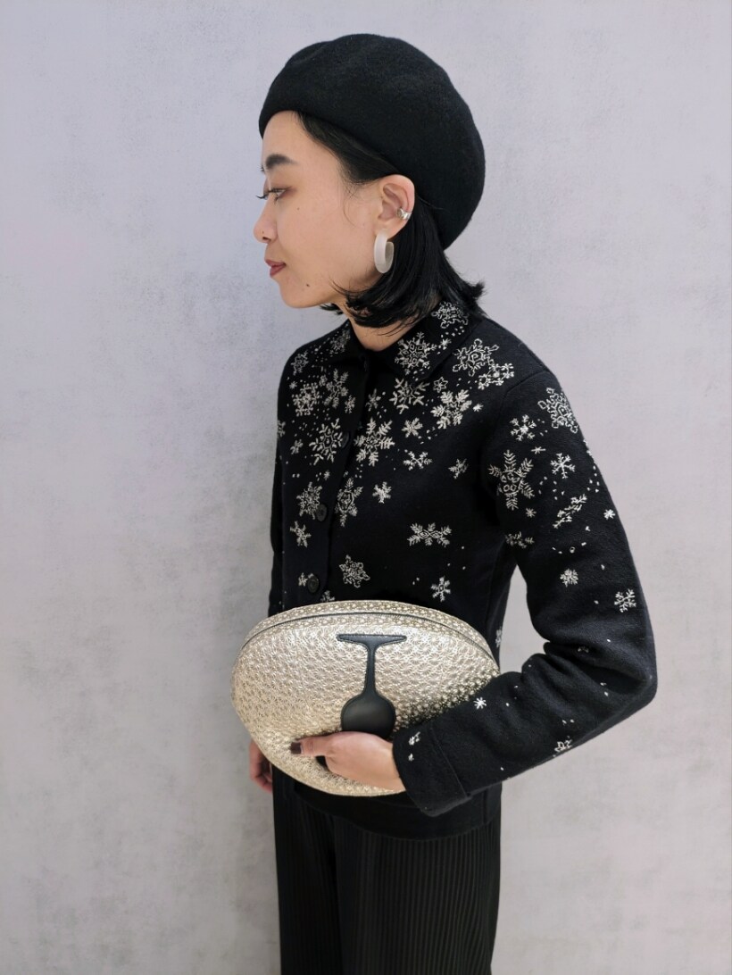 ゴールド系のハンドバッグを着用したレディースの秋コーディネートの2枚目の写真