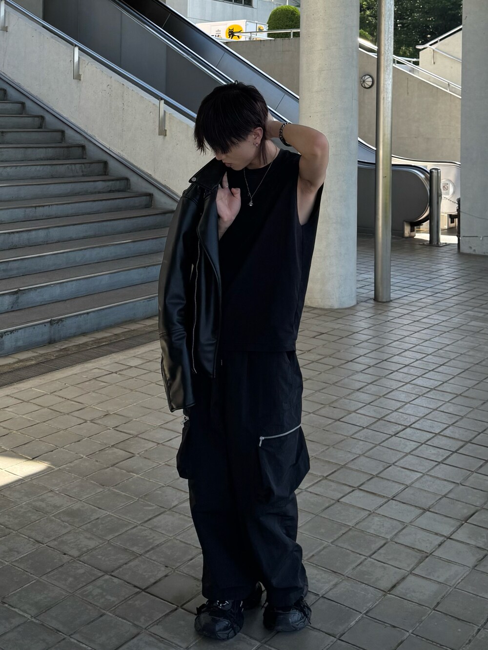 ブラック系のタンクトップ、ブラック系のカーゴパンツ、ブラック系のスニーカーを着用したメンズの春コーディネートの2枚目の写真