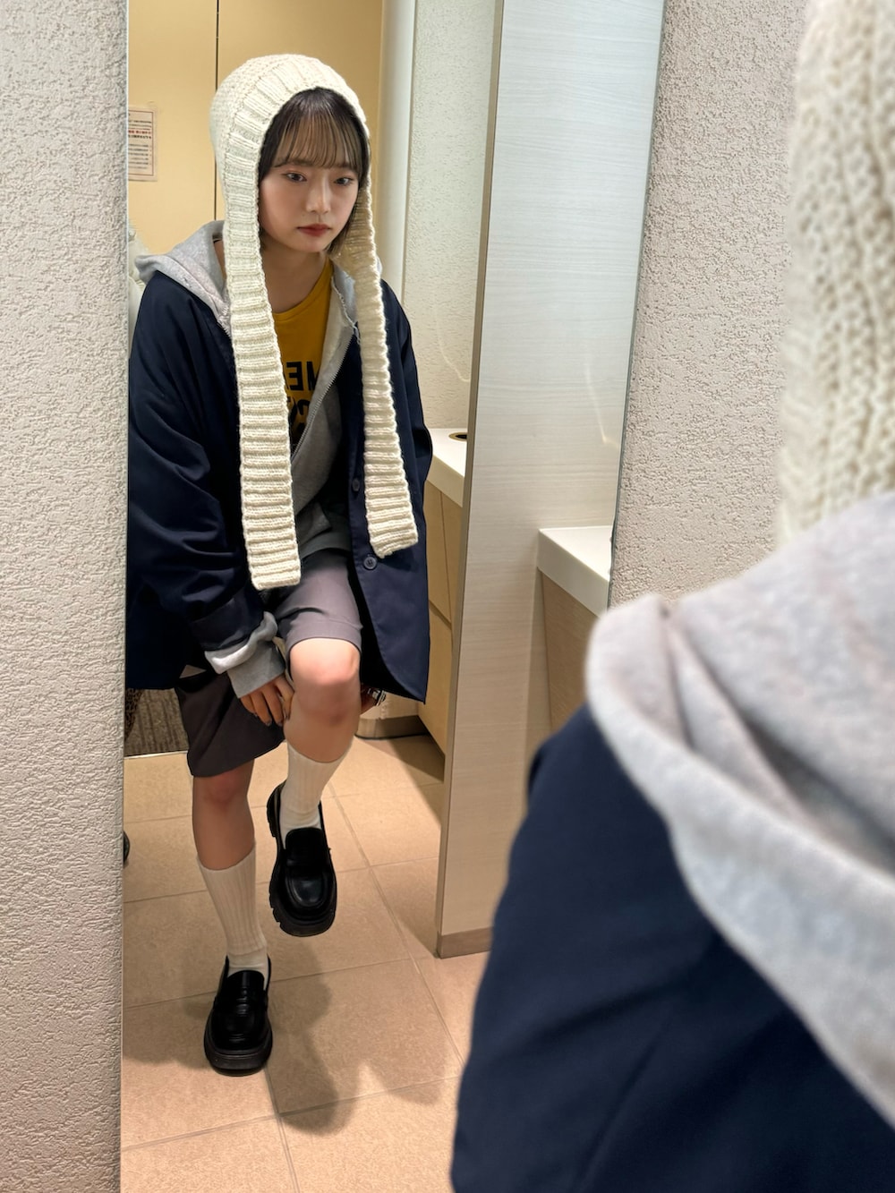 グレー系のその他パンツ、グリーン系のトートバッグ、ホワイト系のニットキャップ/ビーニーを着用したレディースの冬コーディネートの3枚目の写真