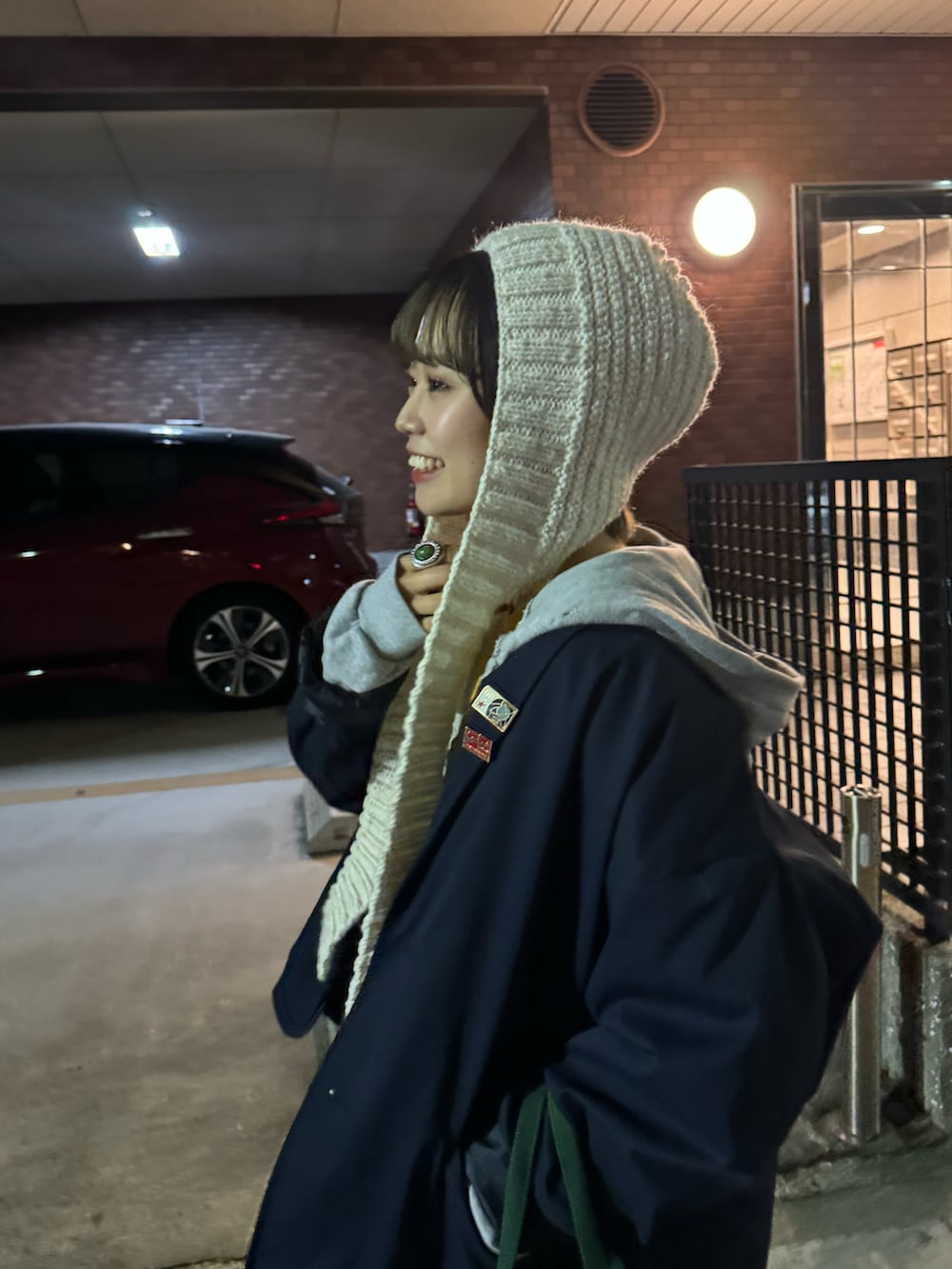 グレー系のその他パンツ、グリーン系のトートバッグ、ホワイト系のニットキャップ/ビーニーを着用したレディースの冬コーディネートの4枚目の写真