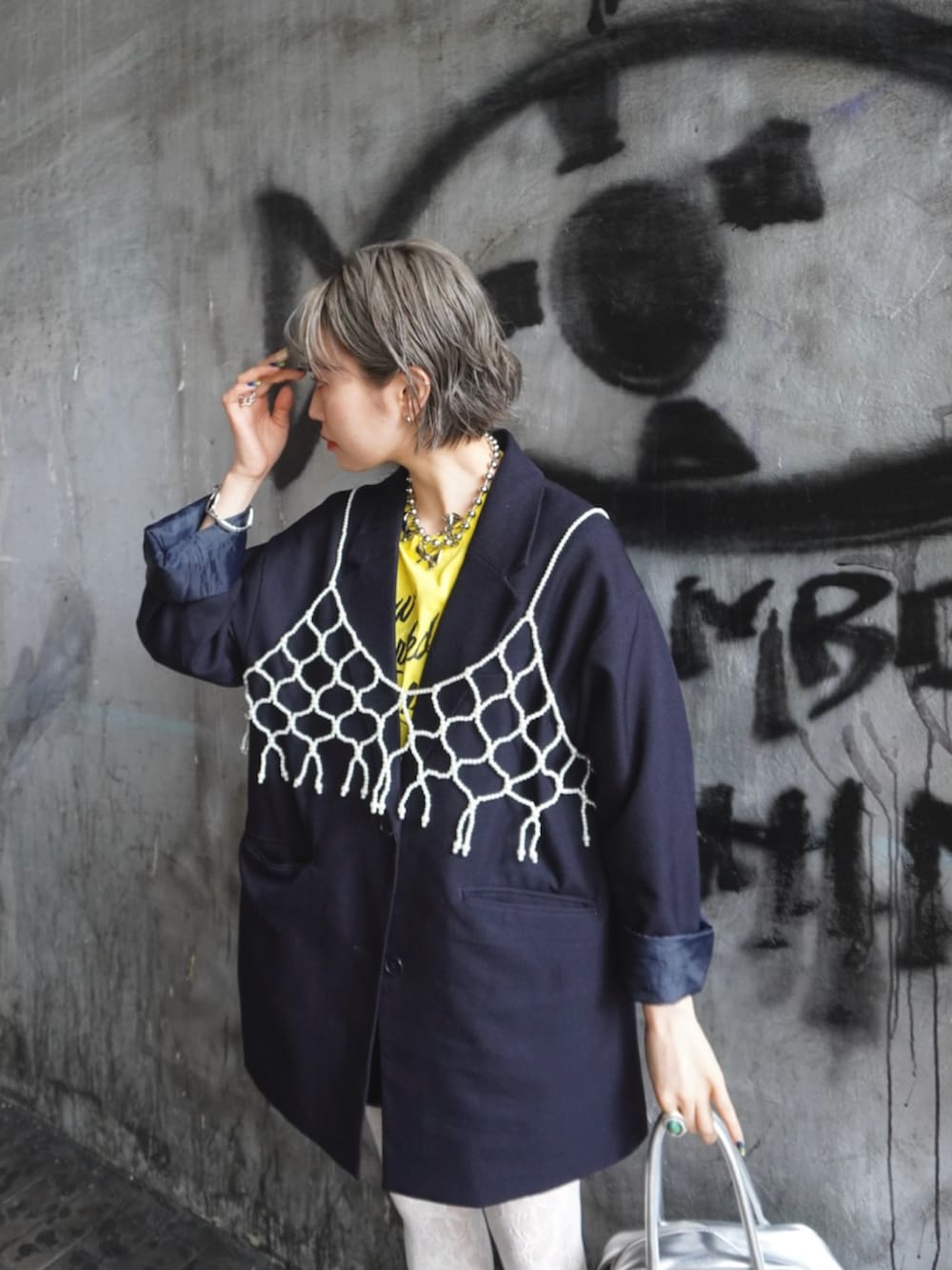 ブルー系のテーラードジャケット、ホワイト系のキャミソール、イエロー系のTシャツ/カットソーを着用したレディースの春コーディネートの5枚目の写真