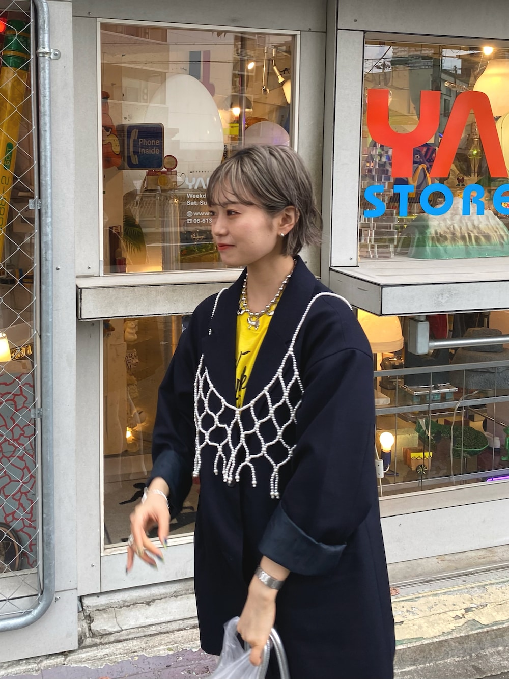 ブルー系のテーラードジャケット、ホワイト系のキャミソール、イエロー系のTシャツ/カットソーを着用したレディースの春コーディネートの3枚目の写真