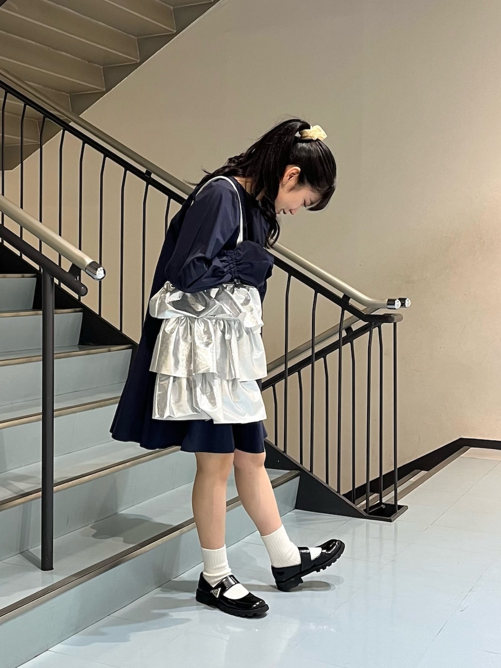 ブルー系のワンピース、シルバー系のトートバッグを着用したレディースの春コーディネートの2枚目の写真