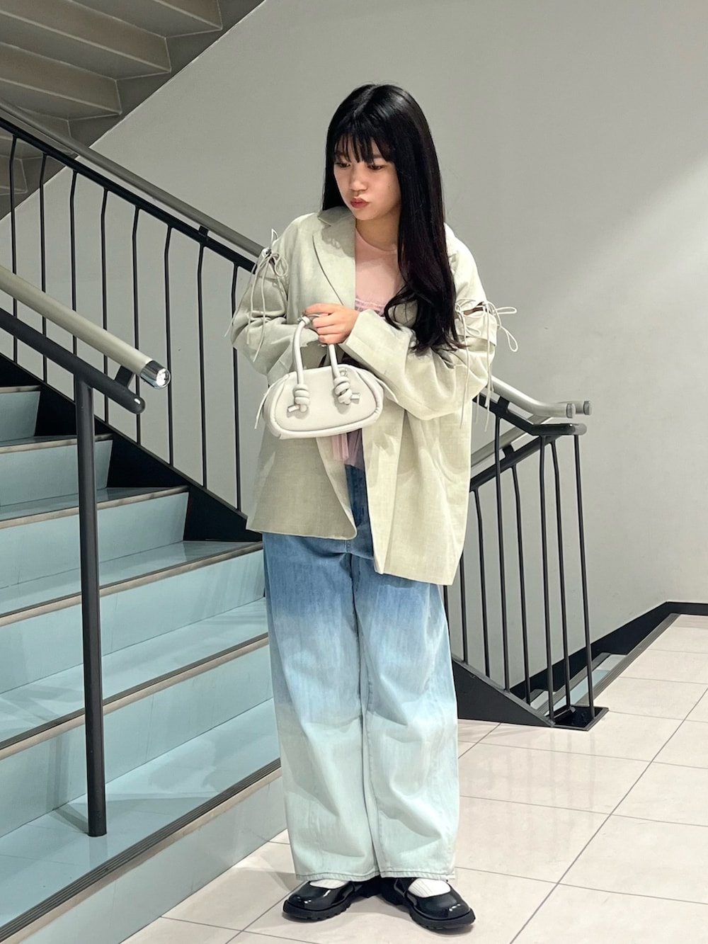 ブルー系のデニムパンツ、グレー系のショルダーバッグ、ピンク系のタンクトップを着用したレディースの春コーディネートの2枚目の写真