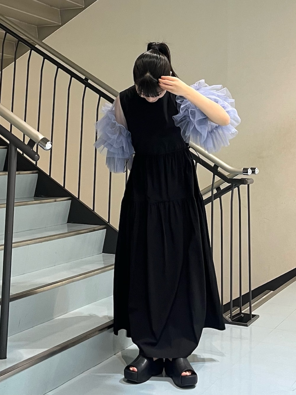 ブラック系のサンダル、ブラック系のワンピース、ブルー系のシャツ/ブラウスを着用したレディースの春コーディネートの3枚目の写真