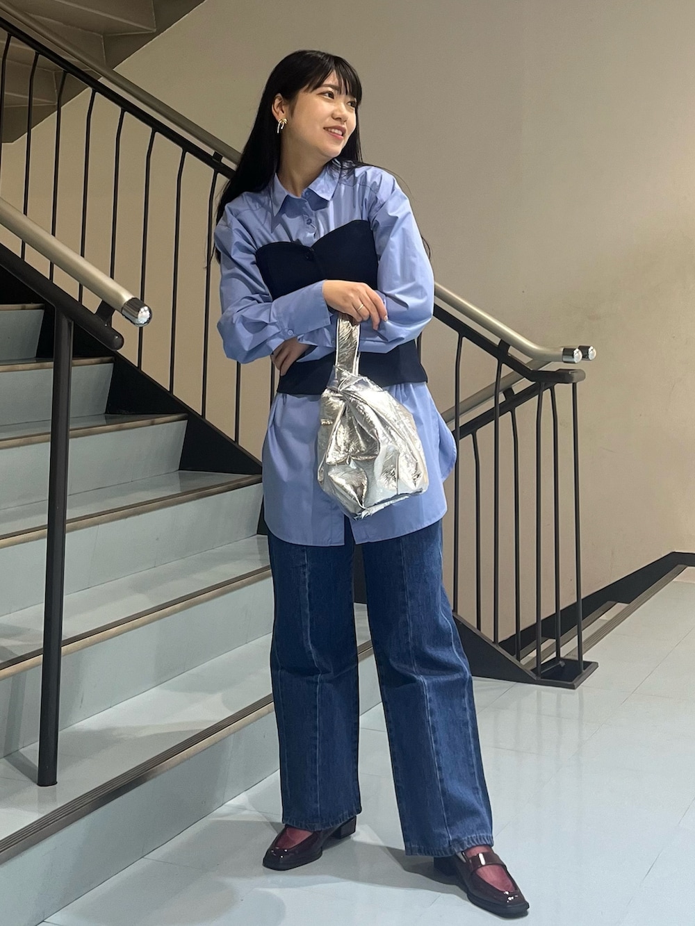 ブルー系のシャツ/ブラウス、ブルー系のデニムパンツ、シルバー系のハンドバッグを着用したレディースの冬コーディネートの2枚目の写真