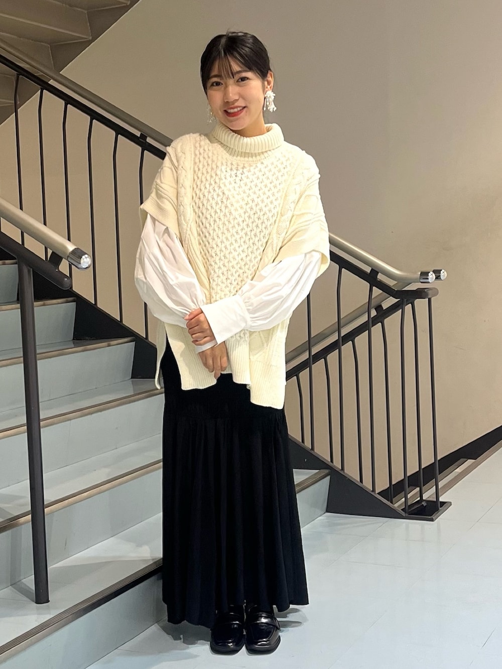 ホワイト系のニット/セーター、ホワイト系のシャツ/ブラウス、ブラック系のスカートを着用したレディースの秋コーディネートの3枚目の写真