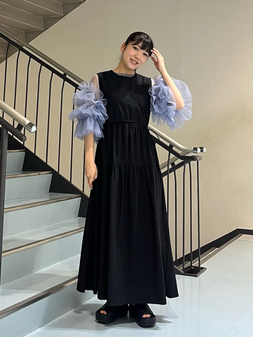 ブラック系のサンダル、ブラック系のワンピース、ブルー系のシャツ/ブラウスを着用したレディースの春コーディネートの2枚目の写真